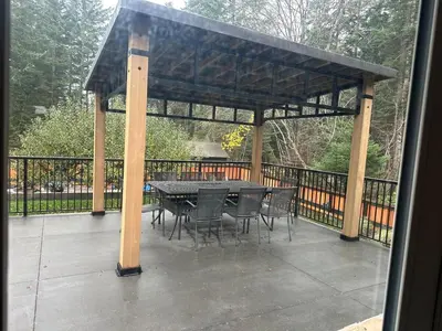 a gazebo with a table and chairs on a patio at Large ocean view family retreat in Comox