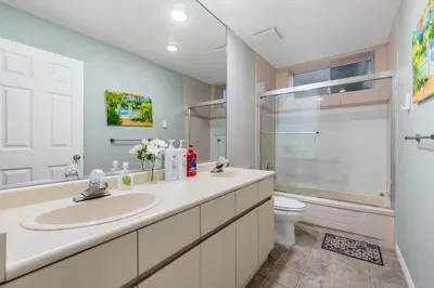 a bathroom with two sinks and a shower and a toilet at Comfortable Westside Vancouver Stay in Vancouver