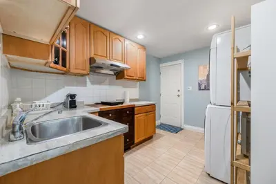 a kitchen with a sink and a white refrigerator at Comfortable Westside Vancouver Stay in Vancouver