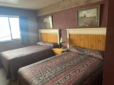 a hotel room with two beds and a window at Logan Lake Hotel in Logan Lake