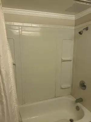 a white bathroom with a shower and a tub at Logan Lake Hotel in Logan Lake