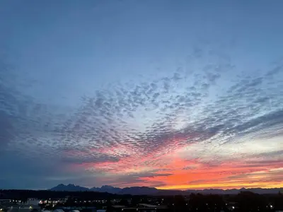 a cloudy sky at sunset with mountains in the background at Modern & Stylish Condo in Langley City in Langley
