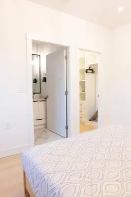 a white bedroom with a large bed and white walls at Elegant Stylish Modern Residence in Vancouver
