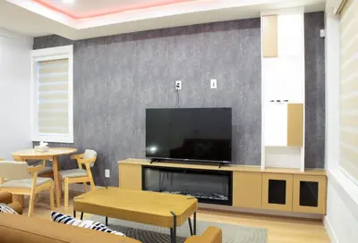 a living room with a flat screen tv on a wall at Elegant Stylish Modern Residence in Vancouver