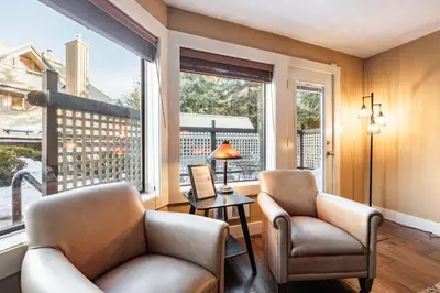 a living room with two chairs and a window at Foxglove 22 by Outpost Whistler in Whistler