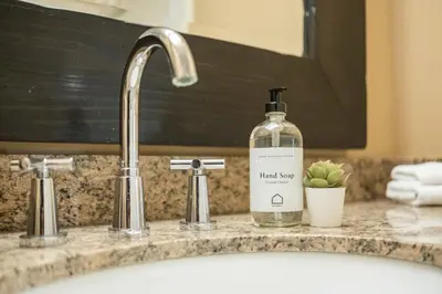 a bottle of liquid soap sitting on a bathroom sink at Foxglove 22 by Outpost Whistler in Whistler