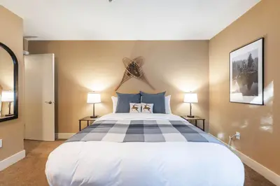 a bedroom with a large white bed with two lamps at Foxglove 22 by Outpost Whistler in Whistler