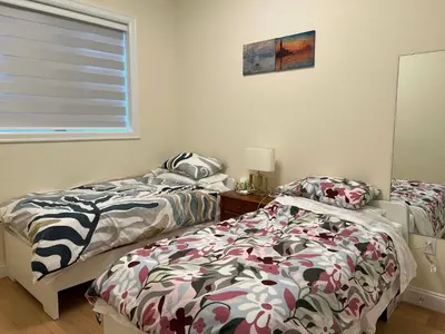 two beds sitting next to each other in a bedroom at SixPine - New 2Br Suite in Vancouver