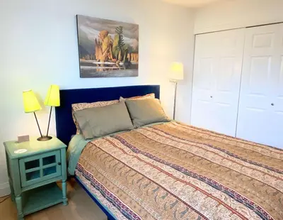 a bedroom with a bed and a painting on the wall at See Aurora and lake from EVERY room - 2bd 2bth in Yellowknife