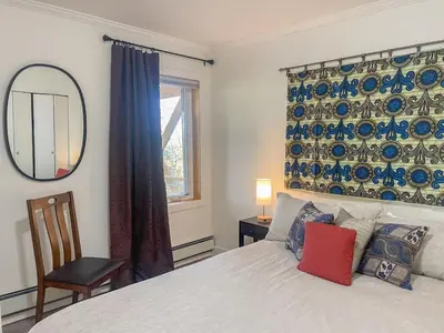 a bedroom with a bed and a mirror and a window at Cozy 1 br apartment in Old Town by lake in Yellowknife
