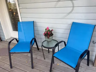 two blue chairs and a table on a porch at Cozy 1 br apartment in Old Town by lake in Yellowknife