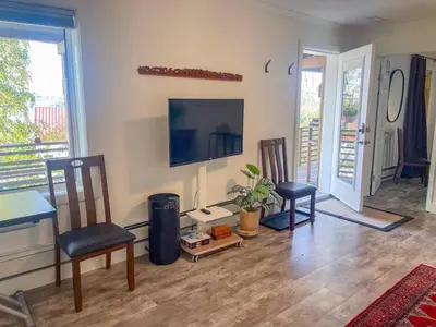 a living room with a television and a table and chairs at Cozy 1 br apartment in Old Town by lake in Yellowknife