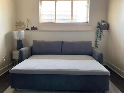 a bed in a living room with a couch at Modern 2BR Retreat Near West Edmonton Mall in Edmonton