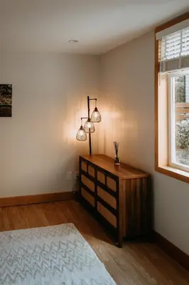 a bedroom with a dresser and two lights on the wall at Quadra Island Mist in Quathiaski Cove