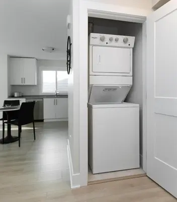a kitchen with a dishwasher and a white appliance at Cozy Corner on Trumpeter in Colwood