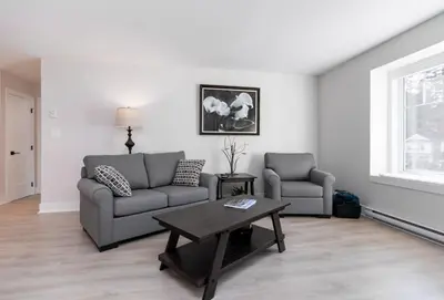 a living room with a couch and a table at Cozy Corner on Trumpeter in Colwood