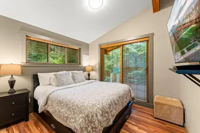 a bedroom with a bed and a large window at JDF Waystation with Bunkhouse - Pet Friendly - sleeps 6 in Port Renfrew