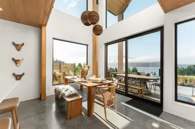 a dining room with large windows and a table and chairs at Hot Tub & Amazing Ocean View -The Simple Peak - Non pet friendly in Port Renfrew