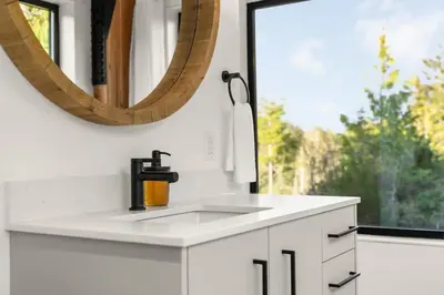 a white bathroom with a sink and a mirror at Hot Tub & Amazing Ocean View -The Simple Peak - Non pet friendly in Port Renfrew