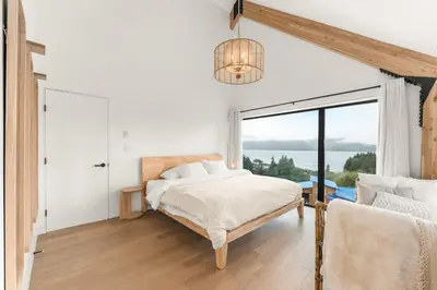 a bedroom with a bed and a large window at Hot Tub & Amazing Ocean View -The Simple Peak - Non pet friendly in Port Renfrew