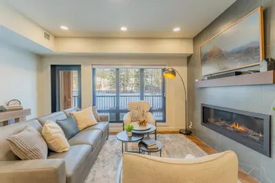 a living room with a couch and a fireplace at Brand New Canmore Condo by Canadian Rockies Vacation Rentals in Canmore