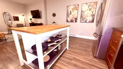 a kitchen with a table and a refrigerator at Fields & Fences Suite in Maple Ridge District Municipality