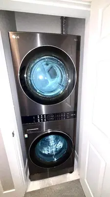 a washing machine in a cabinet in a room at Fields & Fences Suite in Maple Ridge District Municipality
