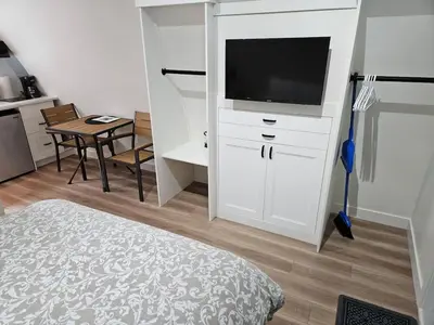 a bedroom with a white cabinet with a television on it at Pet Friendly cozy cabin getaway with Kitchenette and Private Bath in Port Renfrew
