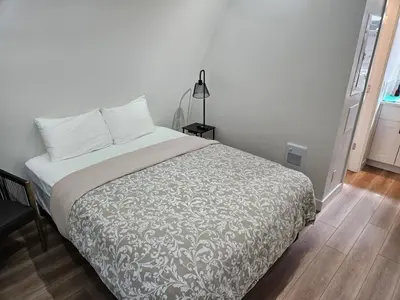 a bedroom with a bed with a white bedspread at Pet Friendly cozy cabin getaway with Kitchenette and Private Bath in Port Renfrew
