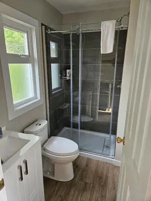 a bathroom with a toilet and a shower at Rustic Rainforest Cabin for 2 - Peaceful - Pet Friendly in Port Renfrew
