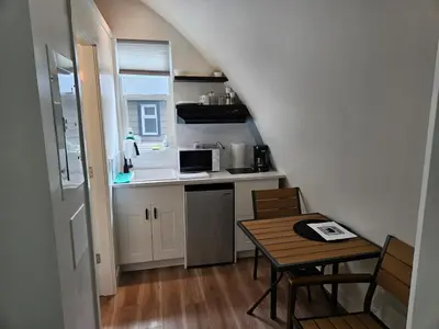 a small kitchen with a table and a sink and a stove at Stylish Cabin Escape w - Kitchenette & Ensuite Bath in Port Renfrew