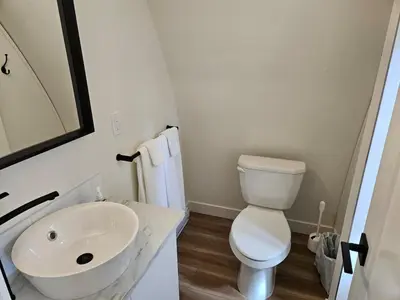 a white bathroom with a sink and a toilet at Stylish Cabin Escape w - Kitchenette & Ensuite Bath in Port Renfrew
