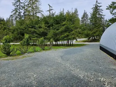 a gravel driveway with trees in the background at Stylish Cabin Escape w - Kitchenette & Ensuite Bath in Port Renfrew