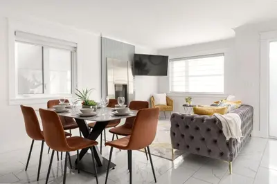 a dining room with a table and chairs and a couch at Family friendly Lux house Near University Train Hospital in Edmonton