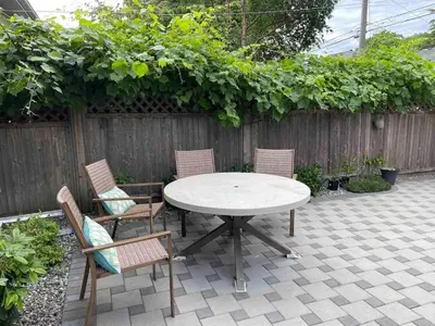 a patio with a table and chairs and a fence at Queen bedroom suite with private bathroom and independent entrance in Kelowna