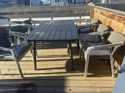 a picnic table and chairs on a deck at Gans Home - 5 Bedroom Residence in Lloydminster
