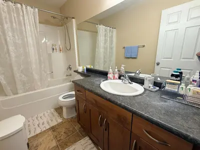 a bathroom with a sink and a toilet and a shower at Gans Home - 5 Bedroom Residence in Lloydminster
