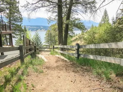 a fence on a hill with a view of the water at Ultimate Family Retreat Beach, Hot Tub & Games in Windermere