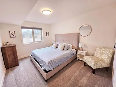 a bedroom with a bed and a mirror and a chair at Ultimate Family Retreat Beach, Hot Tub & Games in Windermere