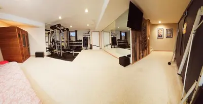 a large living room with a bed and a gym at Family Retreat Hot Tub Banff and Calgary DT Access in Calgary