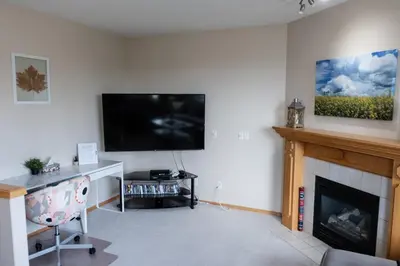 a living room with a fireplace and a flat screen tv at Family Retreat Hot Tub Banff and Calgary DT Access in Calgary
