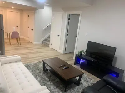 a living room with a white couch and a coffee table at Beautiful one Bedroom Bsmnt suite with sep Entrance in Edmonton