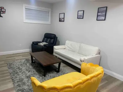 a living room with a couch and a chair at Beautiful one Bedroom Bsmnt suite with sep Entrance in Edmonton