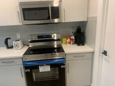 a kitchen with a stove and a microwave at Beautiful one Bedroom Bsmnt suite with sep Entrance in Edmonton