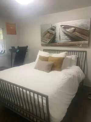 a bed with white sheets and pillows in a bedroom at Quiet-comfy 4 bedroom house on a tree lined street in Kitsilano in Vancouver