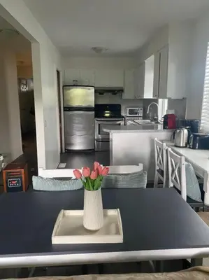 a kitchen with a vase of flowers on a table at Quiet-comfy 4 bedroom house on a tree lined street in Kitsilano in Vancouver