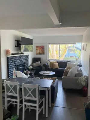 a living room with a couch and a table and chairs at Quiet-comfy 4 bedroom house on a tree lined street in Kitsilano in Vancouver