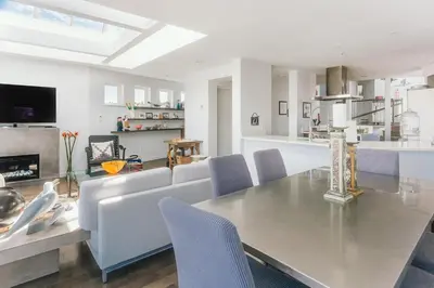 a dining room and living room with a table and chairs at Private Penthouse Beside Beach with Rooftop Patio in Vancouver