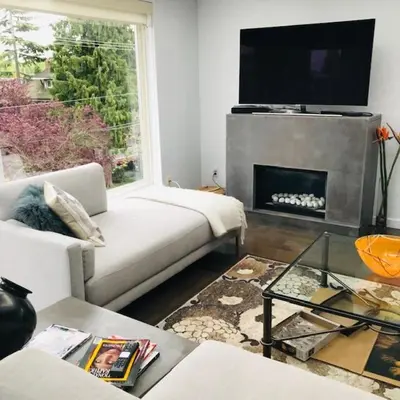 a living room with a white couch and a fireplace at Private Penthouse Beside Beach with Rooftop Patio in Vancouver
