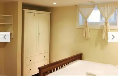 a bedroom with a bed and a dresser and a window at Dunbar Home in Vancouver